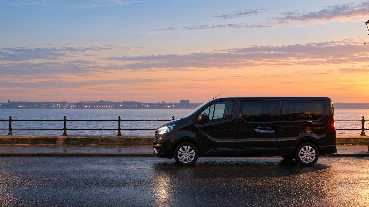A black 2026 Renault Trafic parked on the Wirral waterfront at dawn, the river and the far shore behind it